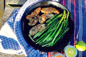 Seglerküche Paellapfanne auf Tisch mit grünem Spargel und Hähnchen BBQ